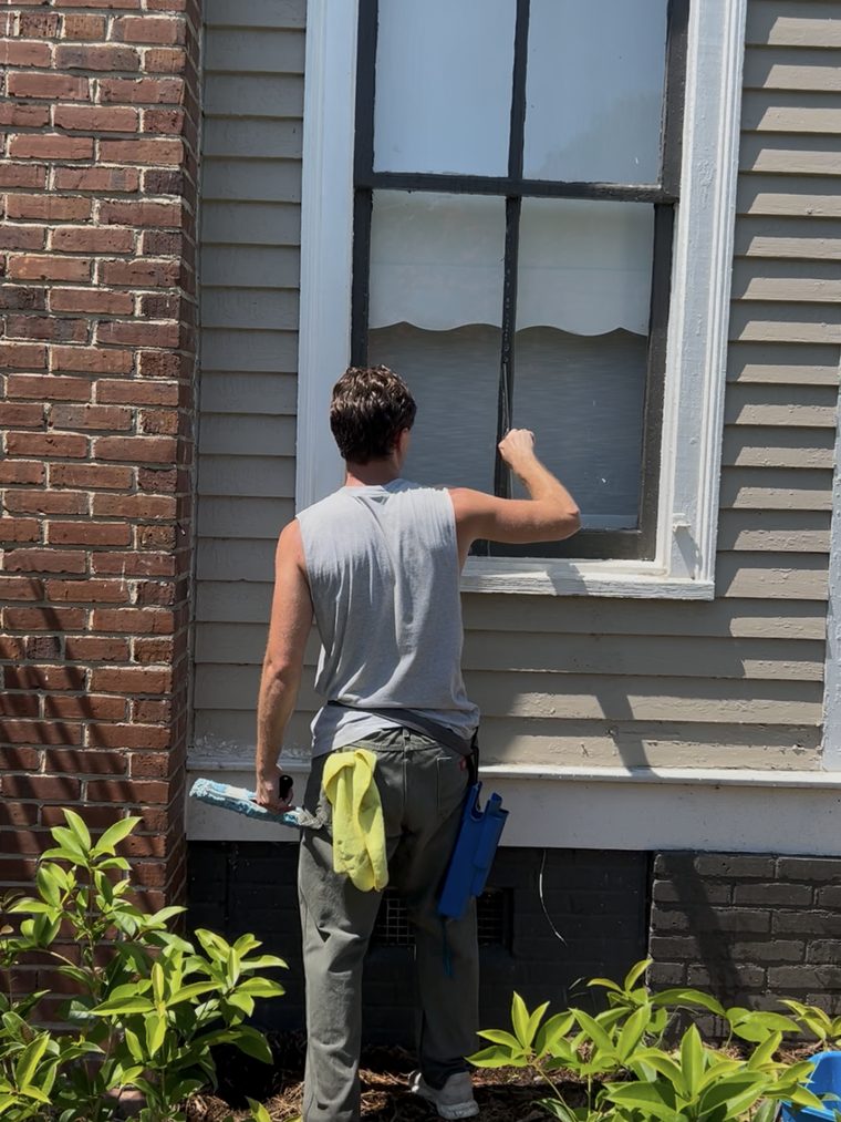 Technician hand-washing a ground-floor window